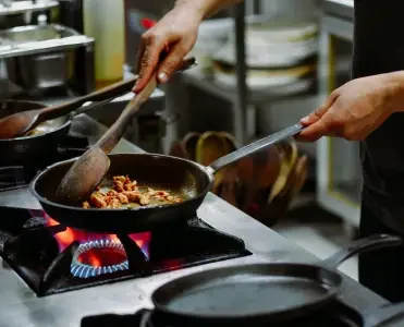 a person cooking food on a stove, melhores panelas