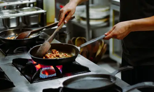 a person cooking food on a stove, melhores panelas